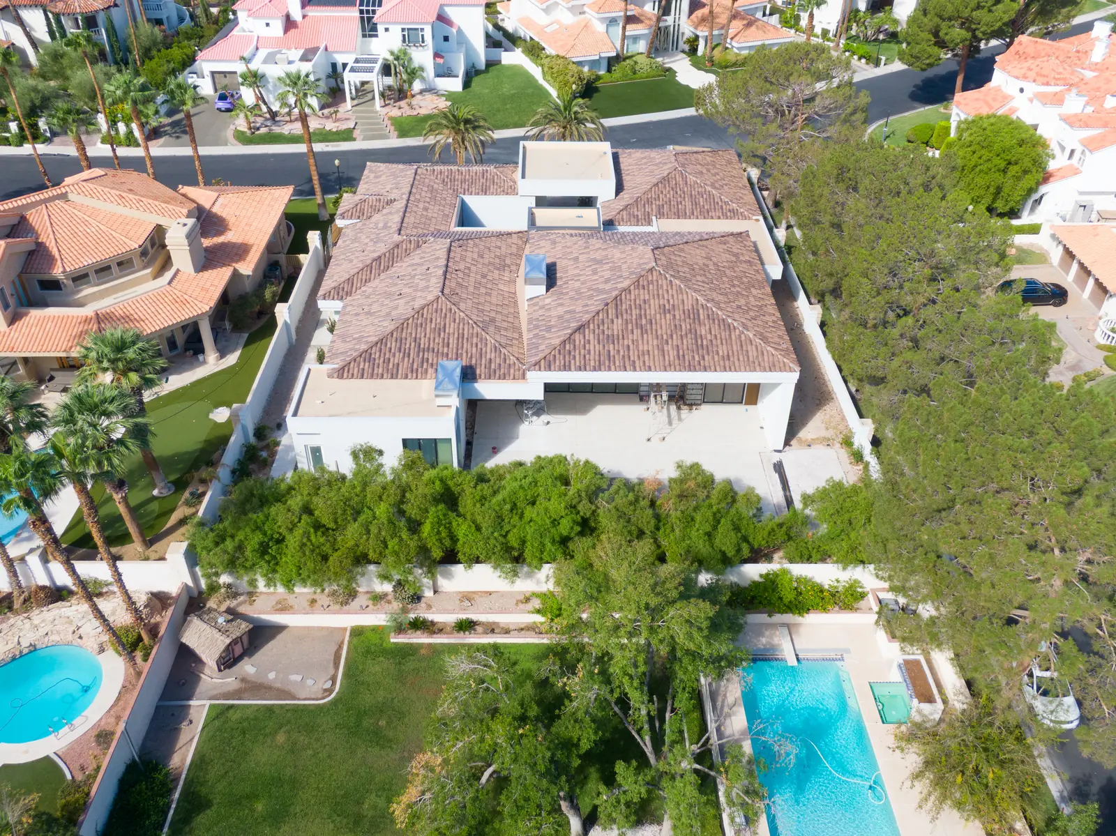 Aerial photograph of the rear of the house with the tiled patio, the rear wall and a tall hedge line along the boundary