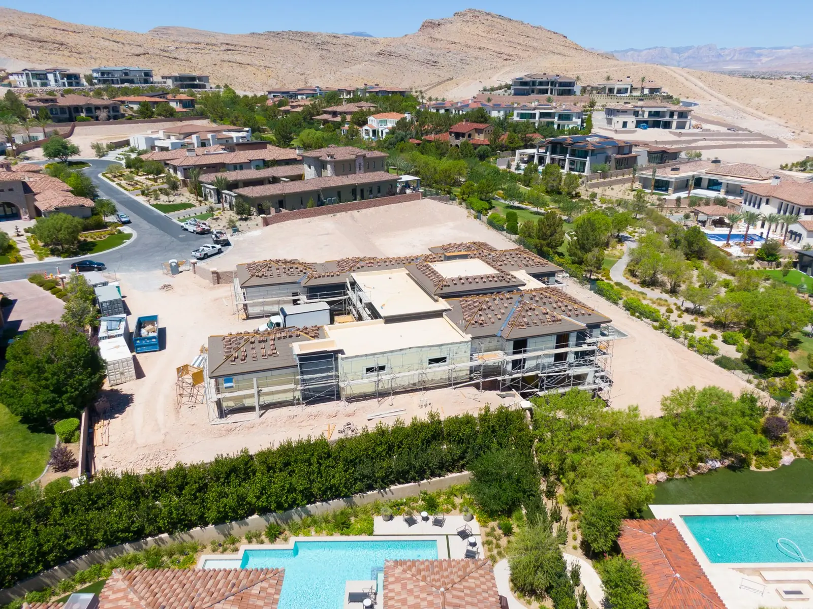 Close aerial over the framed structure with roof tile stacked in bundles