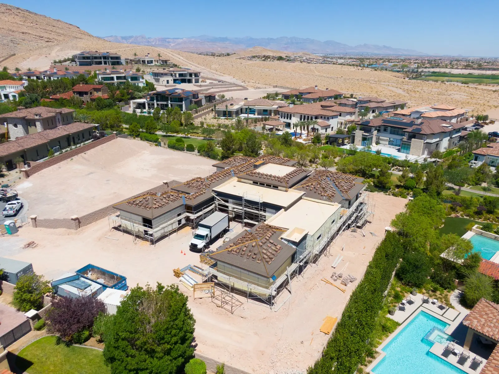 High aerial over 8 Pebble Hills Court showing the whole footprint, the roof deck and the graded pad