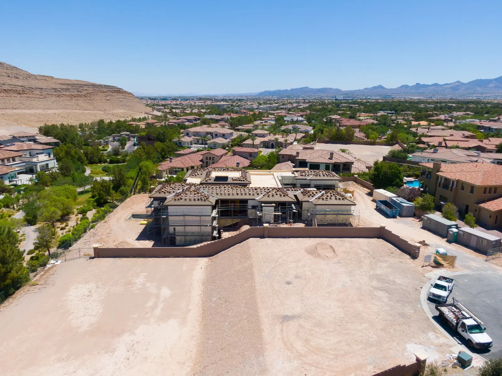 Wide aerial placing the house within Augusta Canyon with the valley in the distance