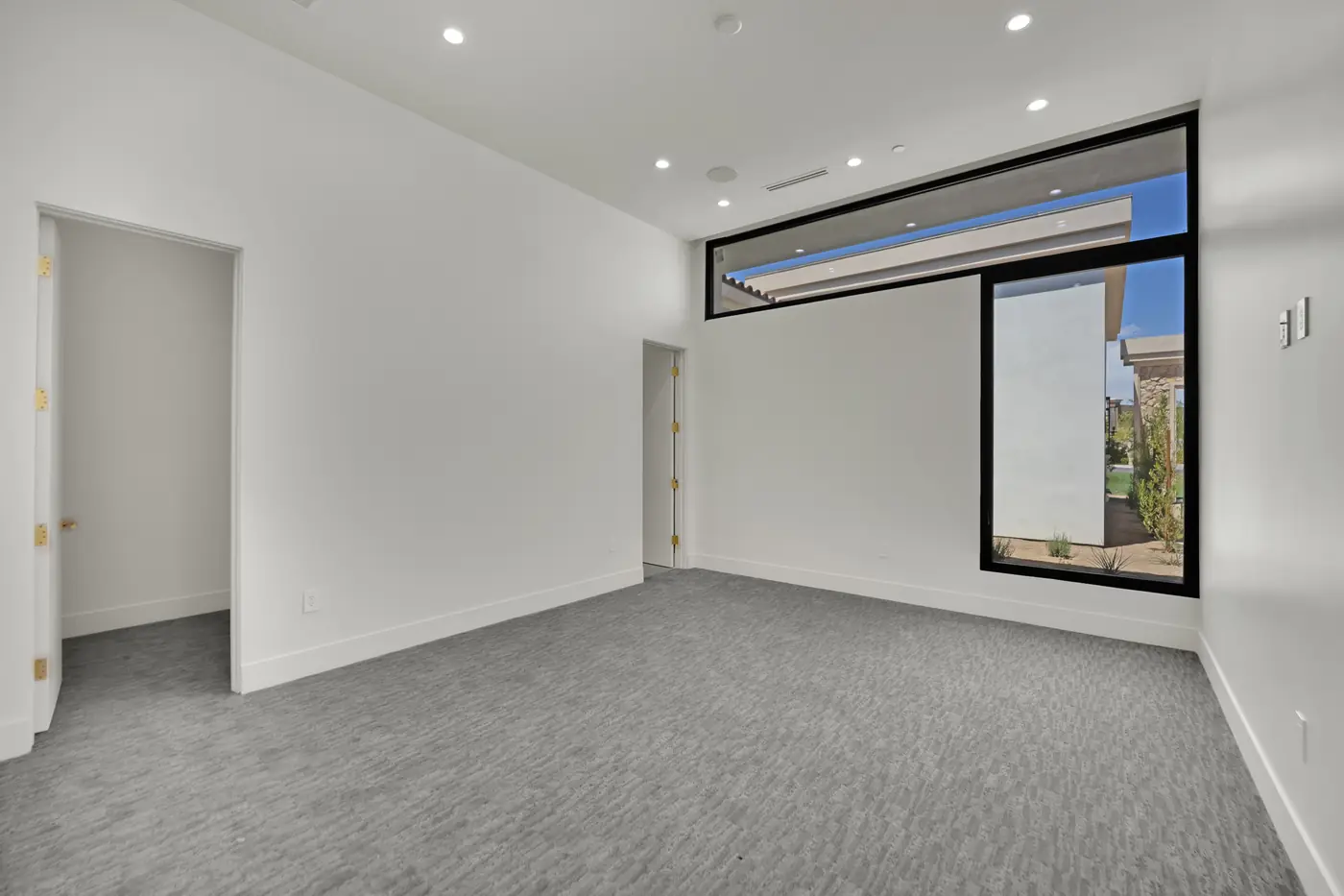 Bedroom with carpet and a corner window onto the side yard