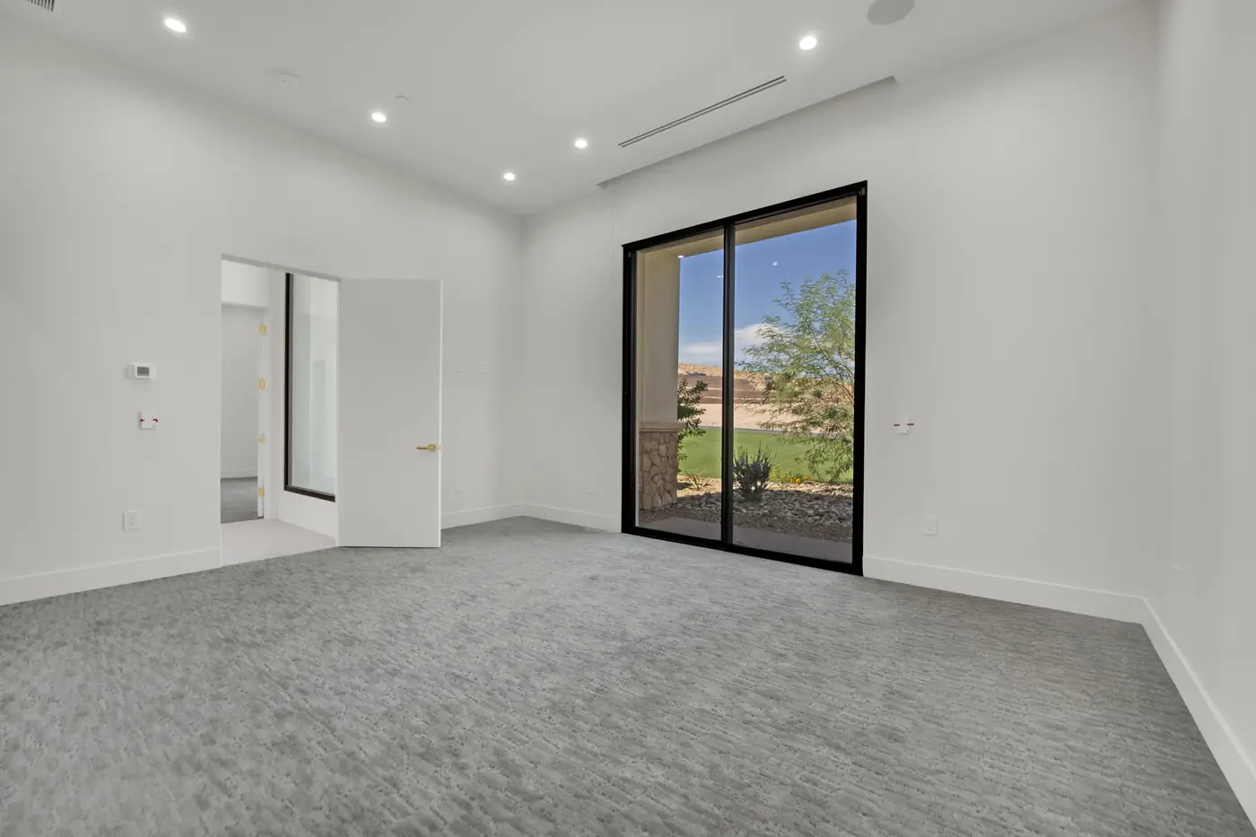 Bedroom with carpet and a sliding glass door onto the yard