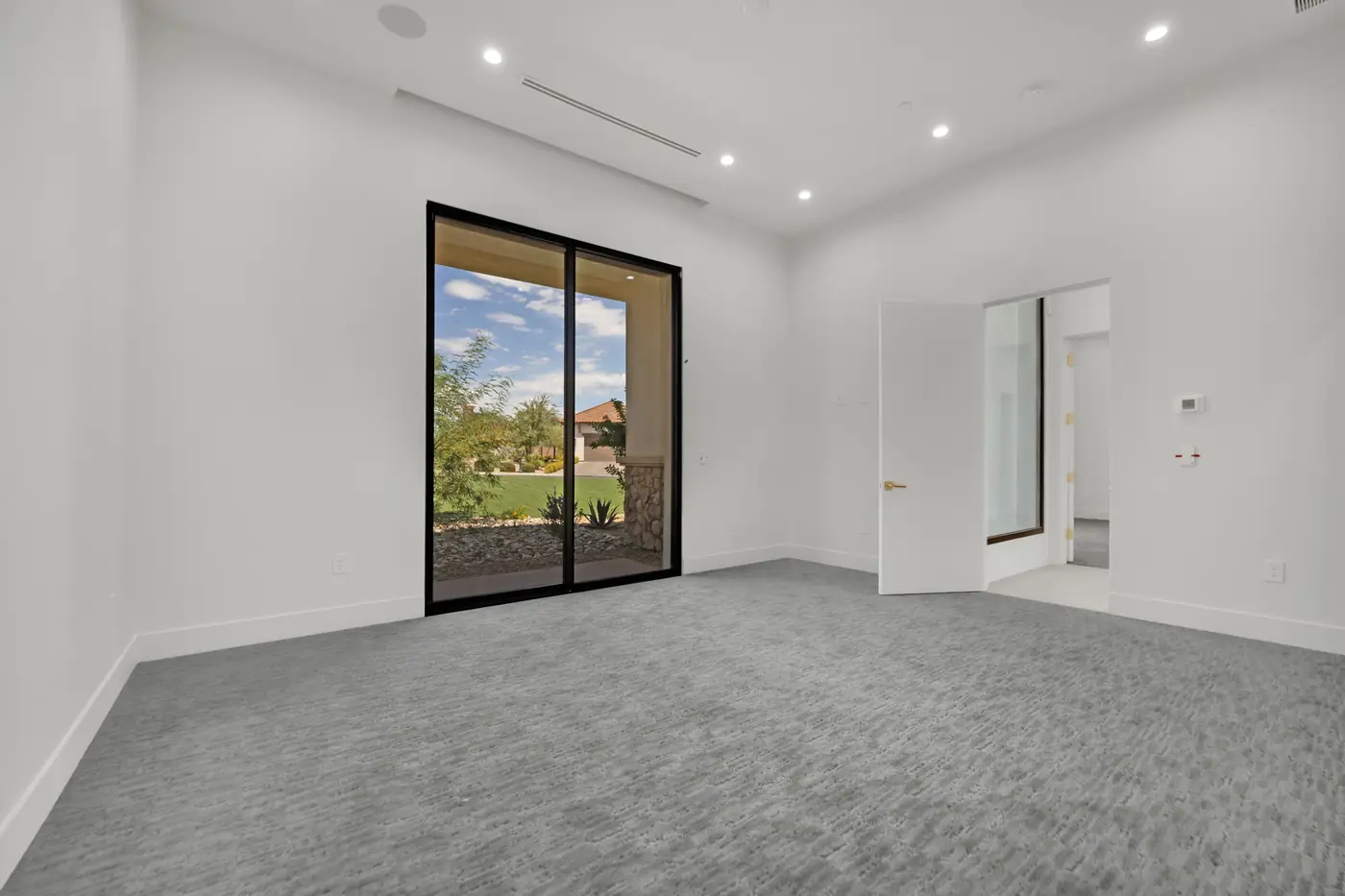 Bedroom with carpet and a slider looking out to the lawn