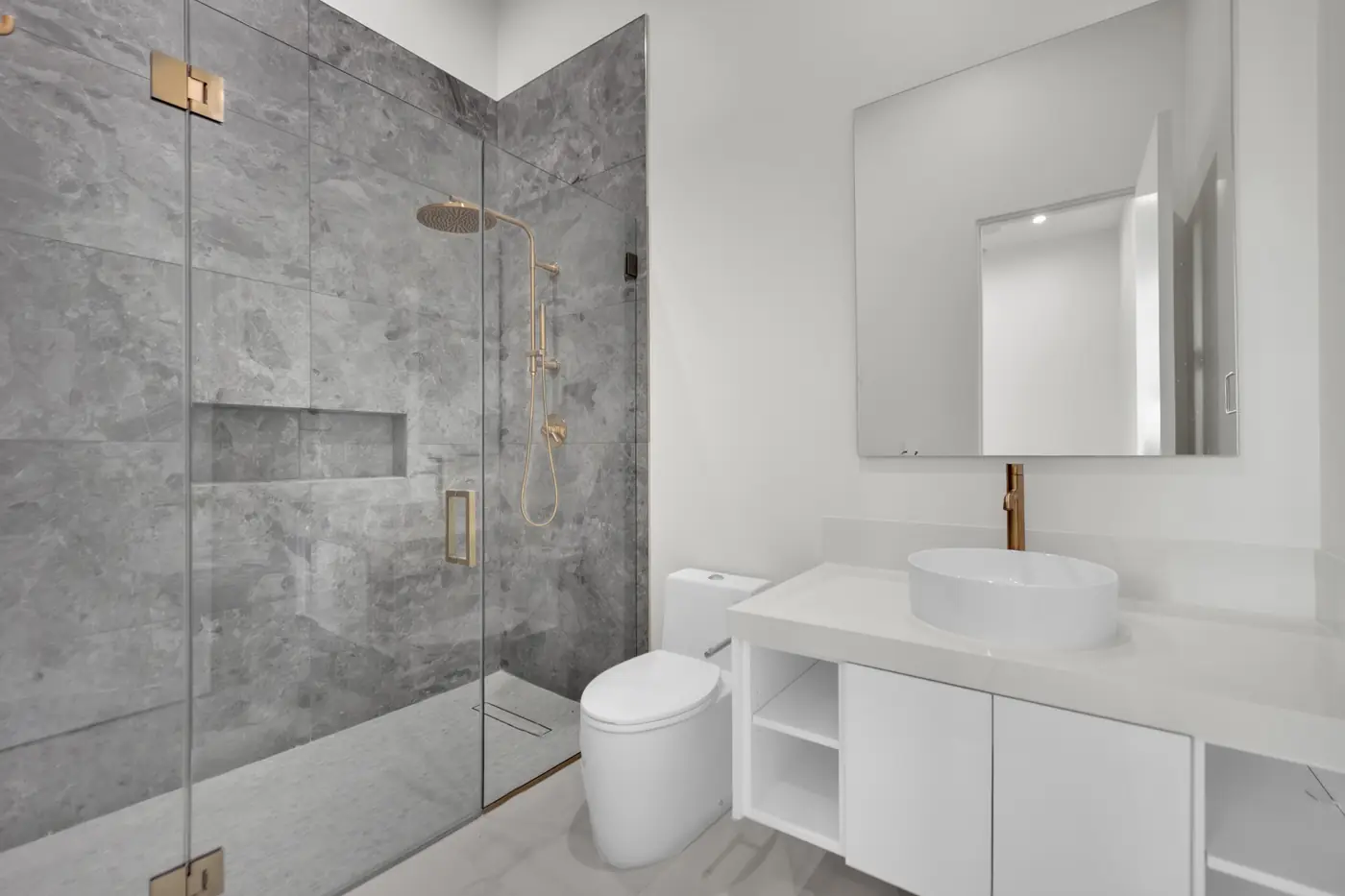 Bath with a marble shower surround and brass fittings