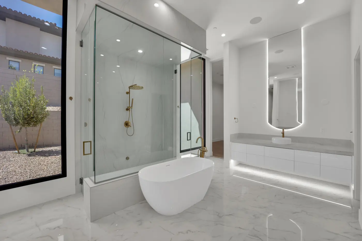 Primary bath from the other side showing the shower and the lit mirror