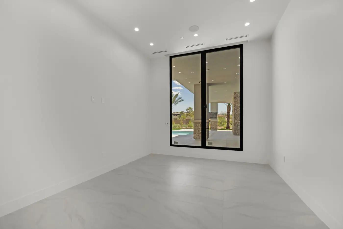 Room with a tile floor and a window looking out to the pool