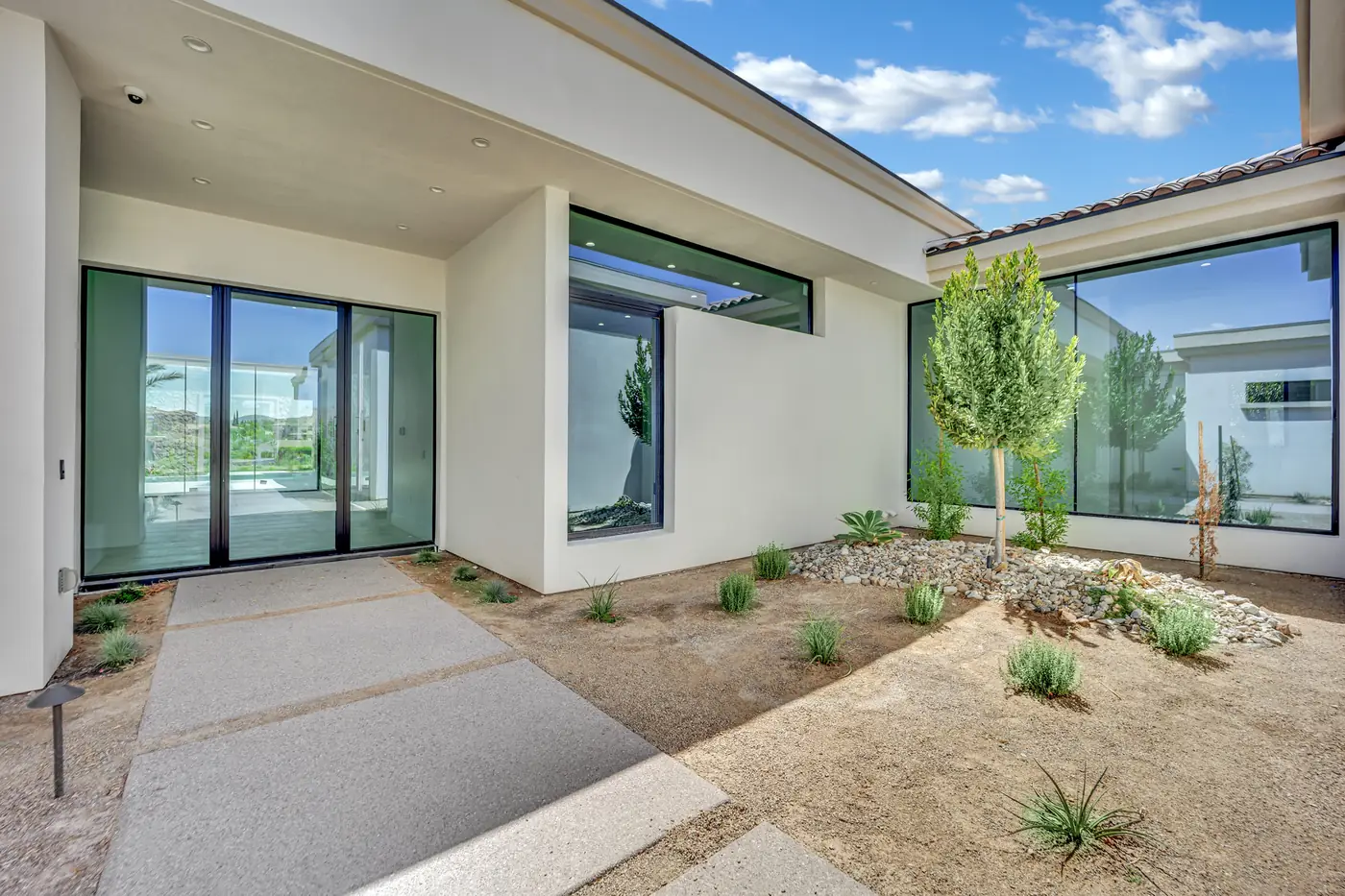 Side courtyard between the wings with young planting and a paved walk