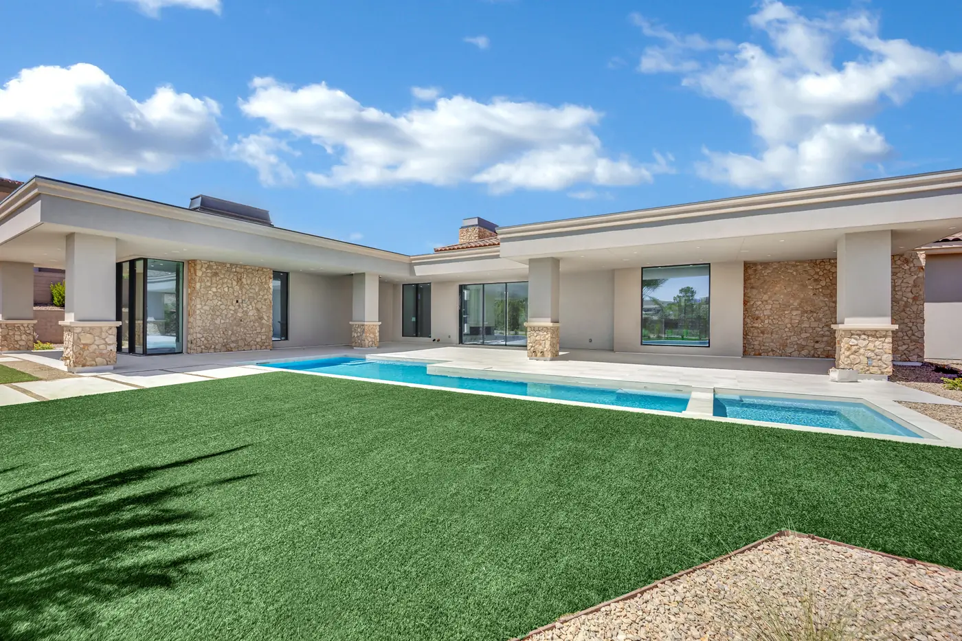 The pool and turf with the house behind, seen from the far side of the yard