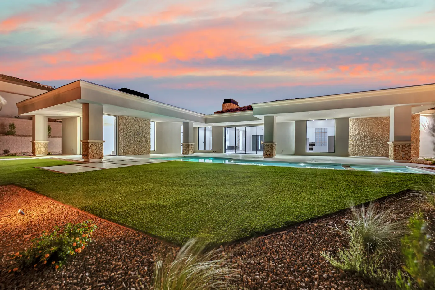 Covered patio at dusk looking down the length of the pool